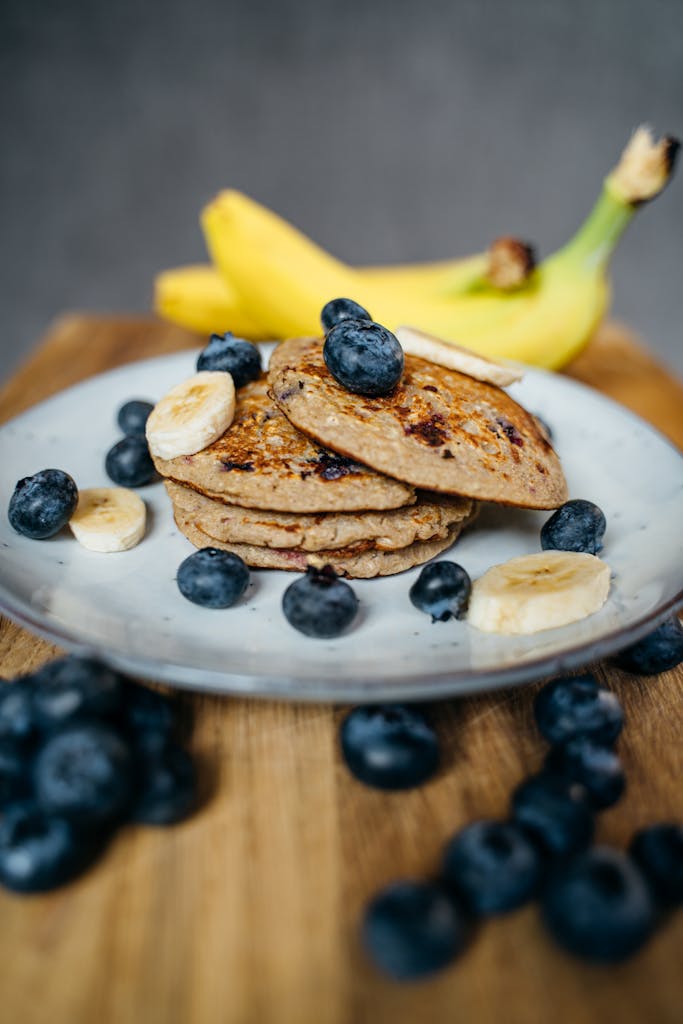 Banana pancakes with blueberries on a plate, perfect for a delicious breakfast.